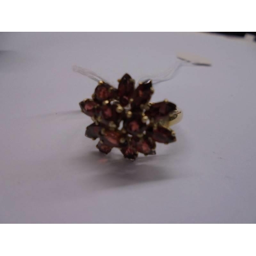 1014 - A 9ct gold red stone cluster ring, size Q half, 3.9 grams.