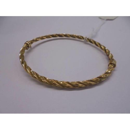 1021 - A 9ct gold twist design bangle, 4.3 grams.