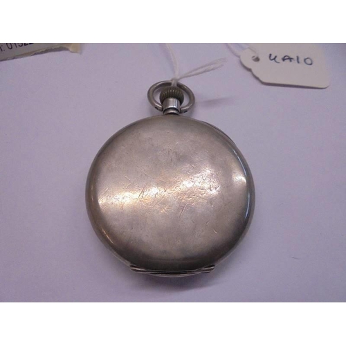 1057 - A silver half hunter pocket watch in working order but missing glass on a carved wooden stand.