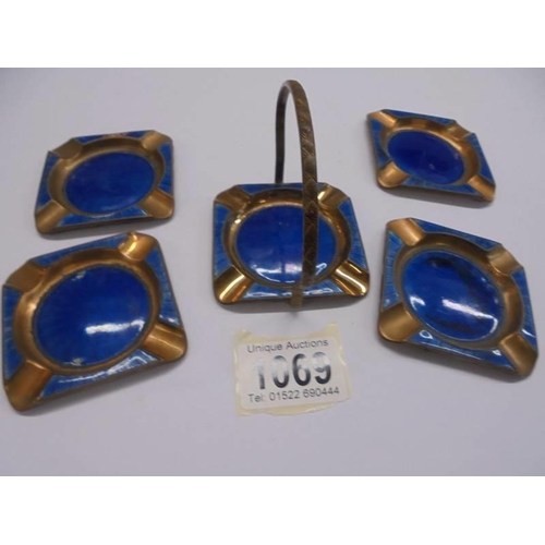 1069 - A copper and enamel ashtray stand with four ashtrays.