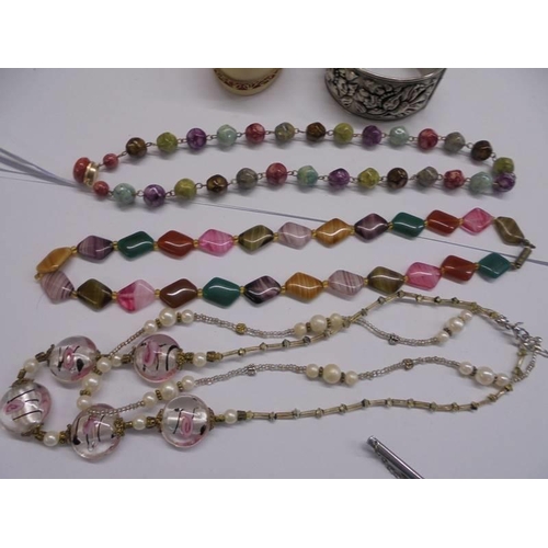 1081 - Three stone necklaces, a white metal bangle, a pill box etc.,