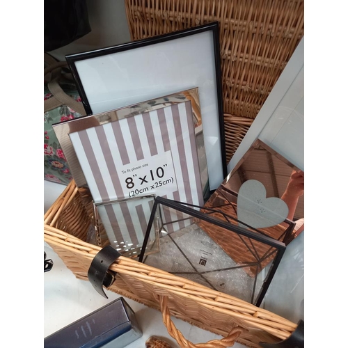 19 - A wicker hamper and quantity of modern photo frames