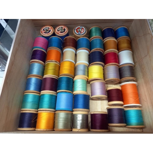 77 - A sewing box with cotton reels and a box of buttons