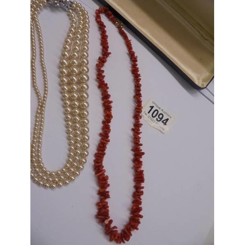 1094 - A three strand pearl necklace and a coral necklace.