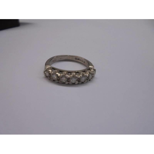 1121 - An 18ct white gold ring set seven diamonds, size F half, 3.5 grams.