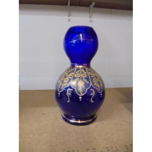 1142 - A pair of hand decorated blue glass vases. 16.5cm.