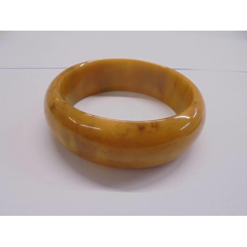 1167 - A jade bangle and a bakelite bangle.