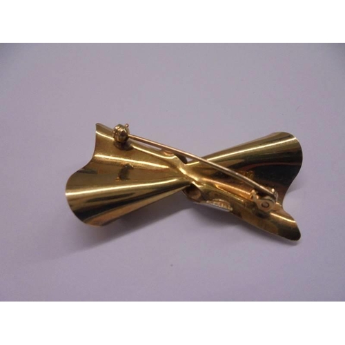 1100G - A brooch designed as a bow in 9ct gold, 3.4 grams.