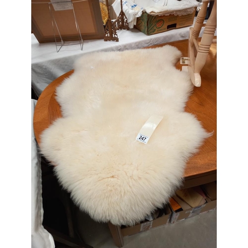 247 - A sheepskin rug 94cm x 60cm at widest parts