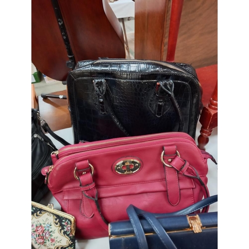 305 - A good selection of ladies modern and vintage handbags, umbrellas, scarf, purse etc