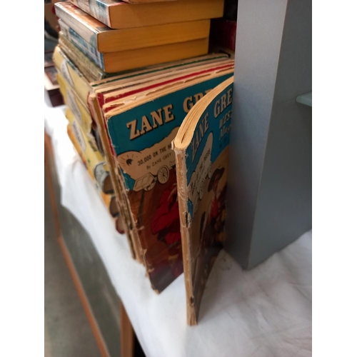 70 - A large quantity of hardback books by Zane Grey, also includes a few paperbacks and some small magaz... 