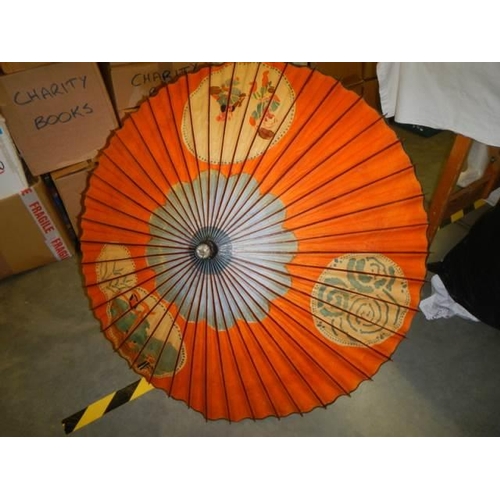 555 - An oriental hand painted parasol.