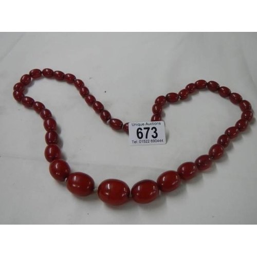 673 - An amber coloured necklace.