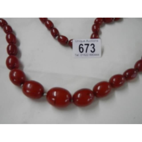 673 - An amber coloured necklace.