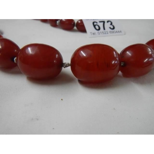 673 - An amber coloured necklace.