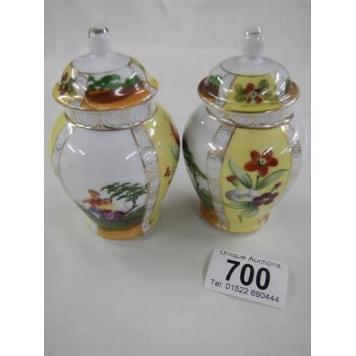 700 - A pair of small hand painted lidded vases.