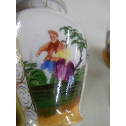 700 - A pair of small hand painted lidded vases.