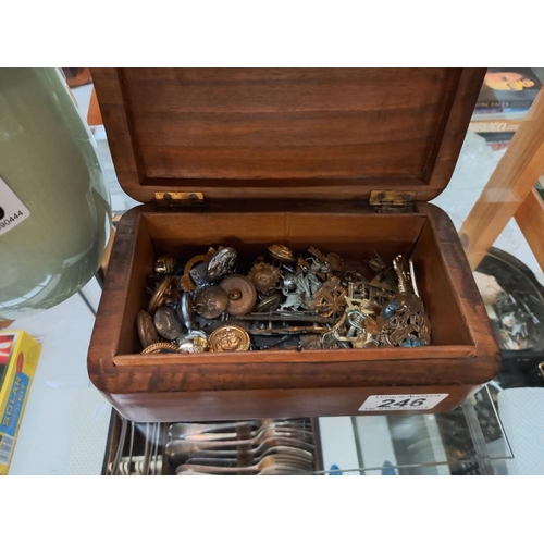 246 - A carved teak box with Royal Army Ordnance Corps emblem and contents of military buttons and badges