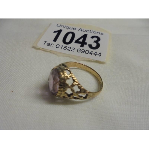 1043 - A large oval amethyst yellow gold ring, size J half, 2.5 grams.