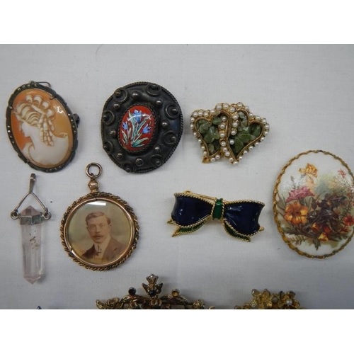 1051 - A good lot of vintage brooches including cameo, photo pendant etc.,