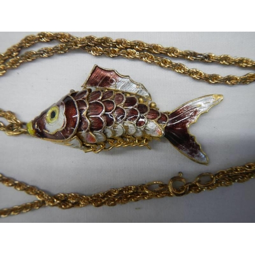 1055 - A mid 20th century enamel articulated fish pendant on yellow metal chain.