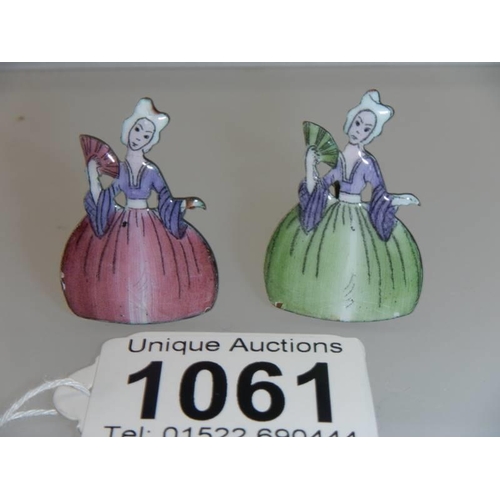 1061 - A pair of early 20th century crinoline lady place card holders, 3.5 cm tall.