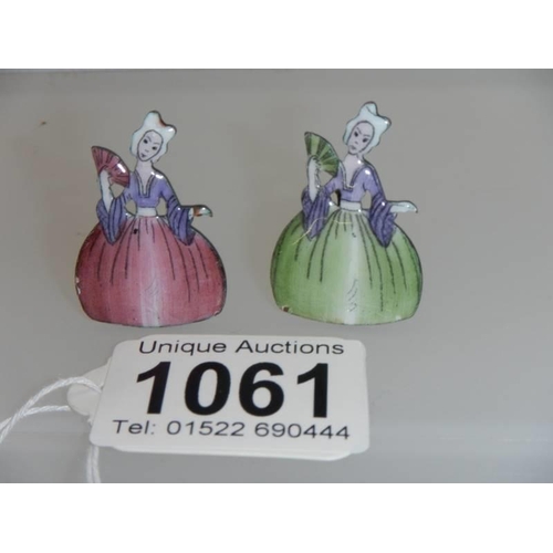 1061 - A pair of early 20th century crinoline lady place card holders, 3.5 cm tall.