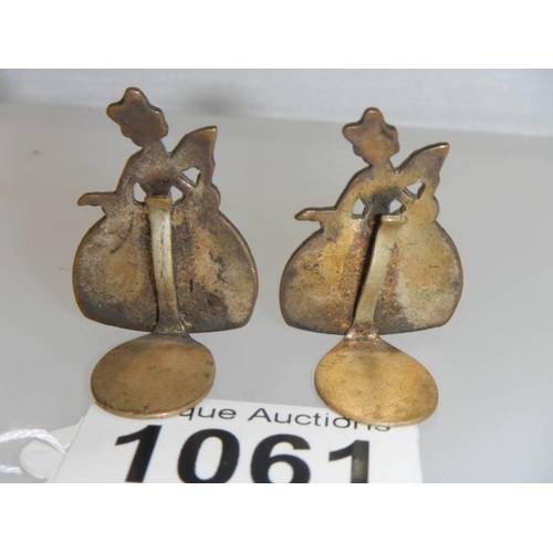 1061 - A pair of early 20th century crinoline lady place card holders, 3.5 cm tall.