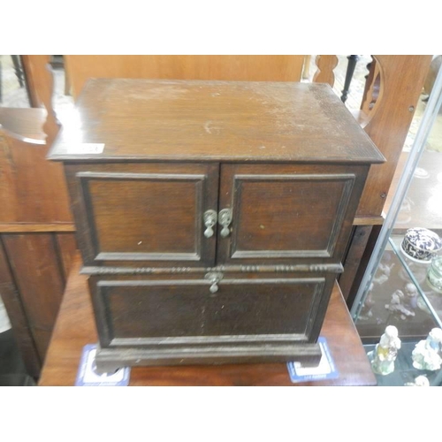 1638 - A 1930's oak cabinet with two doors, removable bolt-on front panel and lift up lid,  43 X 29 X 46 cm... 