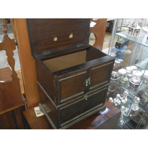 1638 - A 1930's oak cabinet with two doors, removable bolt-on front panel and lift up lid,  43 X 29 X 46 cm... 