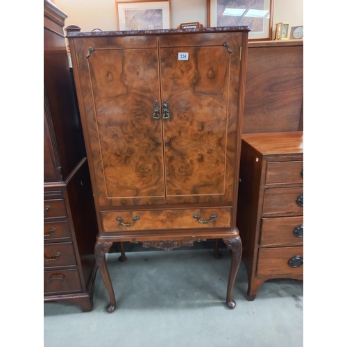 334 - An early 20th century walnut veneered cocktail cabinet. COLLECT ONLY.