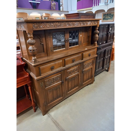 337 - A 1930's solid oak buffet with lead glazed doors. COLLECT ONLY.