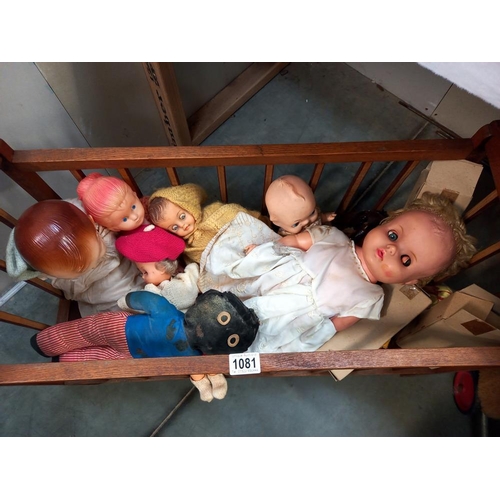 1081 - A vintage wooden dolls cot and contents COLLECT ONLY