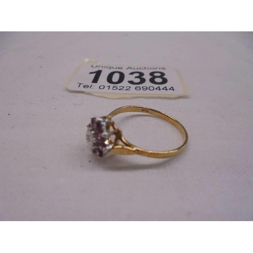 1038 - A yellow gold dark saphire with central diamond ring, size N, 1.3 grams.