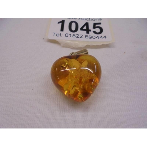 1045 - A 14ct gold set amber heart pendant.