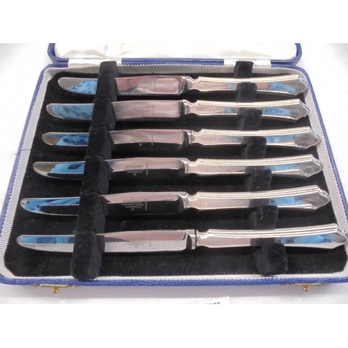 1065 - A cased set of six silver handled knives.