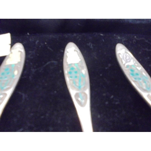 1070 - A set of 6 1976 silver and enamel year of the rose teaspoons.