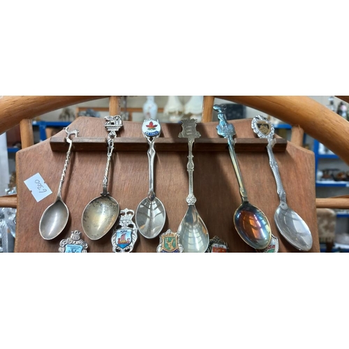 1585 - A display of tourist collectors spoons including silver and enamelled examples