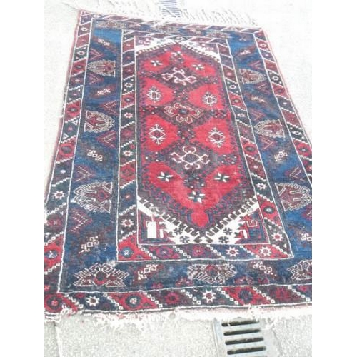 531 - A good old rug in a blue and red pattern, 76 x 50 inches. COLLECT ONLY.