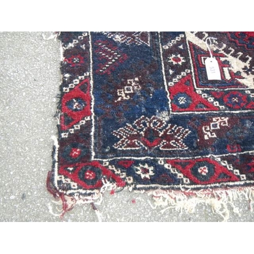 531 - A good old rug in a blue and red pattern, 76 x 50 inches. COLLECT ONLY.