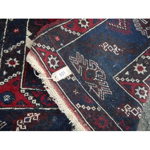 531 - A good old rug in a blue and red pattern, 76 x 50 inches. COLLECT ONLY.