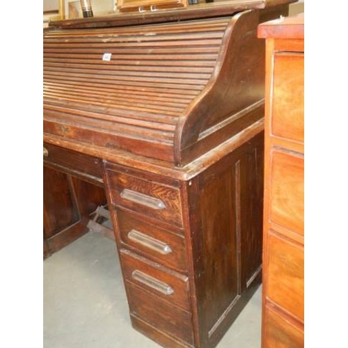 540 - An early 20th century single pedestal roll top desk in fair condition, COLLECT ONLY.