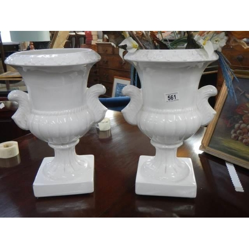 561 - A good pair of white ceramic urns, COLLECT ONLY.