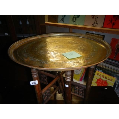 598 - A folding table with brass top. COLLECT ONLY.