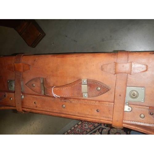 621 - An old leather suitcase with straps. COLLECT ONLY.