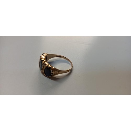 1060B - A 9ct gold ring wit dark blue stones, Size O (3.6g)