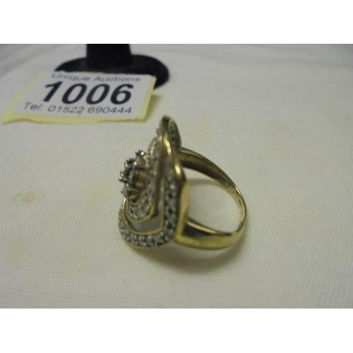 1006 - A 9ct yellow gold large swirl diamond set ring, size N, 3.1 grams.