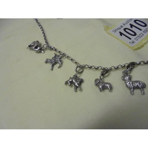 1010 - A long silver chain with forteen animal related charms,