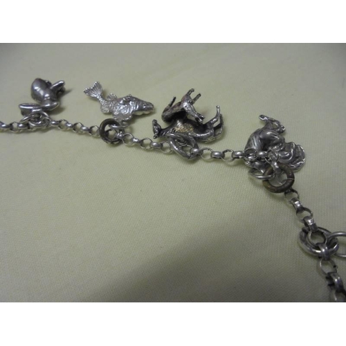 1010 - A long silver chain with forteen animal related charms,