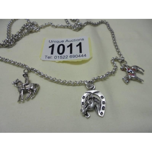 1011 - A long silver chain with three silver charms,